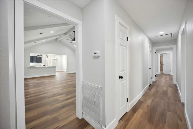 a view of a hallway with wooden floor windows and a living room
