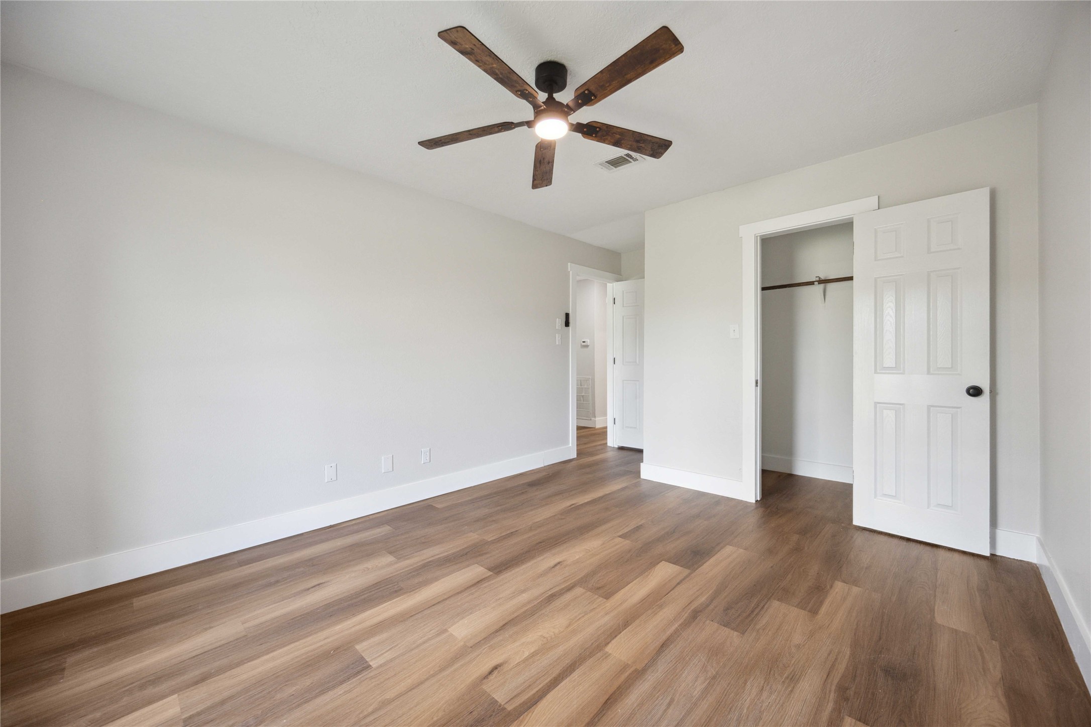 7907 12 Fairway Lane Humble, TX 77346 - Photo 26 of 42 an empty room with wooden floor and ceiling fan