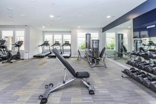 a view of a room with gym equipment and floor to ceiling window