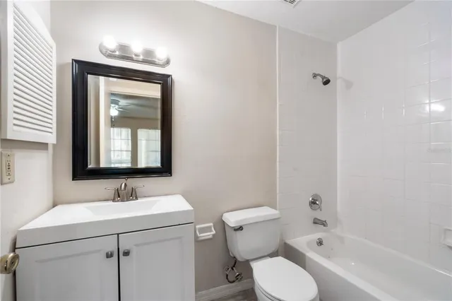 a bathroom with a granite countertop toilet a sink and a mirror