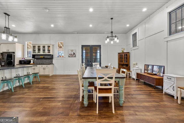 a kitchen with stainless steel appliances granite countertop a stove top oven a sink dishwasher and a refrigerator with wooden floor