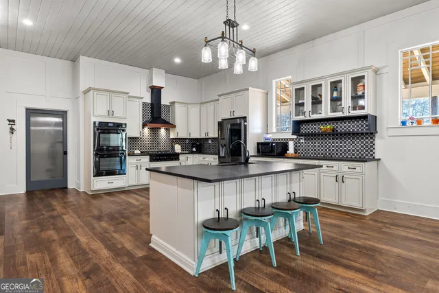 a dining room with wooden floor a chandelier a wooden table and chairs