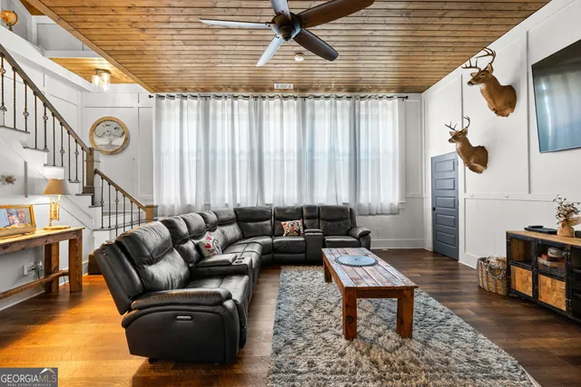 a view of a hallway with wooden floor and living room