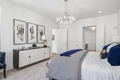a spacious bedroom with a bed and a chandelier