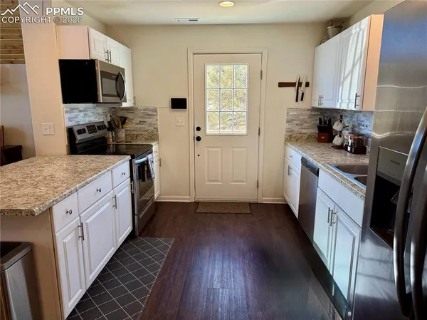 a kitchen with stainless steel appliances a stove a microwave a sink and cabinets