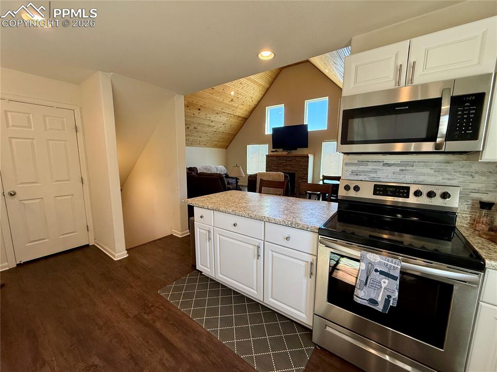 61 Stripling Lane Divide, CO 80814 - Photo 12 of 47 a kitchen with stainless steel appliances a stove a microwave a sink and cabinets