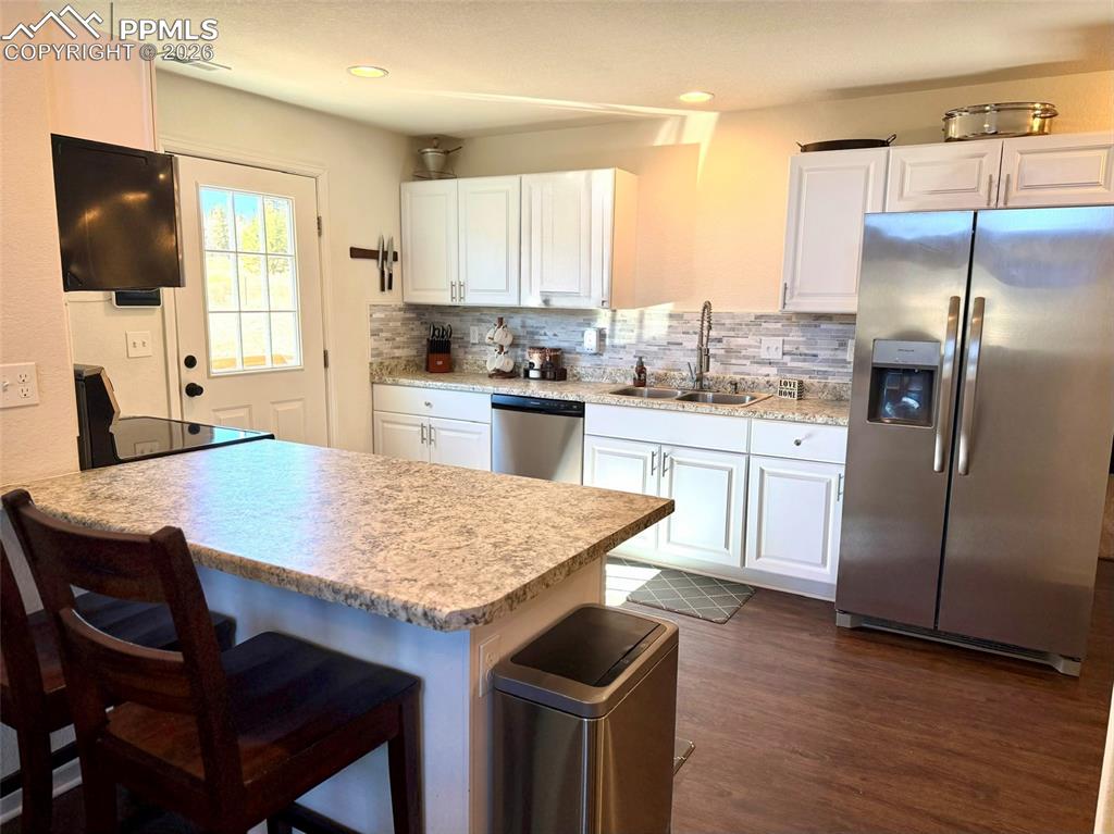 61 Stripling Lane Divide, CO 80814 - Photo 8 of 47 a kitchen with stainless steel appliances granite countertop a table chairs sink refrigerator and microwave