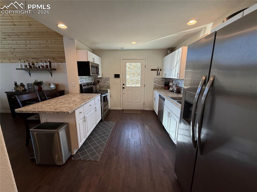61 Stripling Lane Divide, CO 80814 - Photo 9 of 47 a kitchen with stainless steel appliances granite countertop a stove top oven a sink dishwasher and a refrigerator