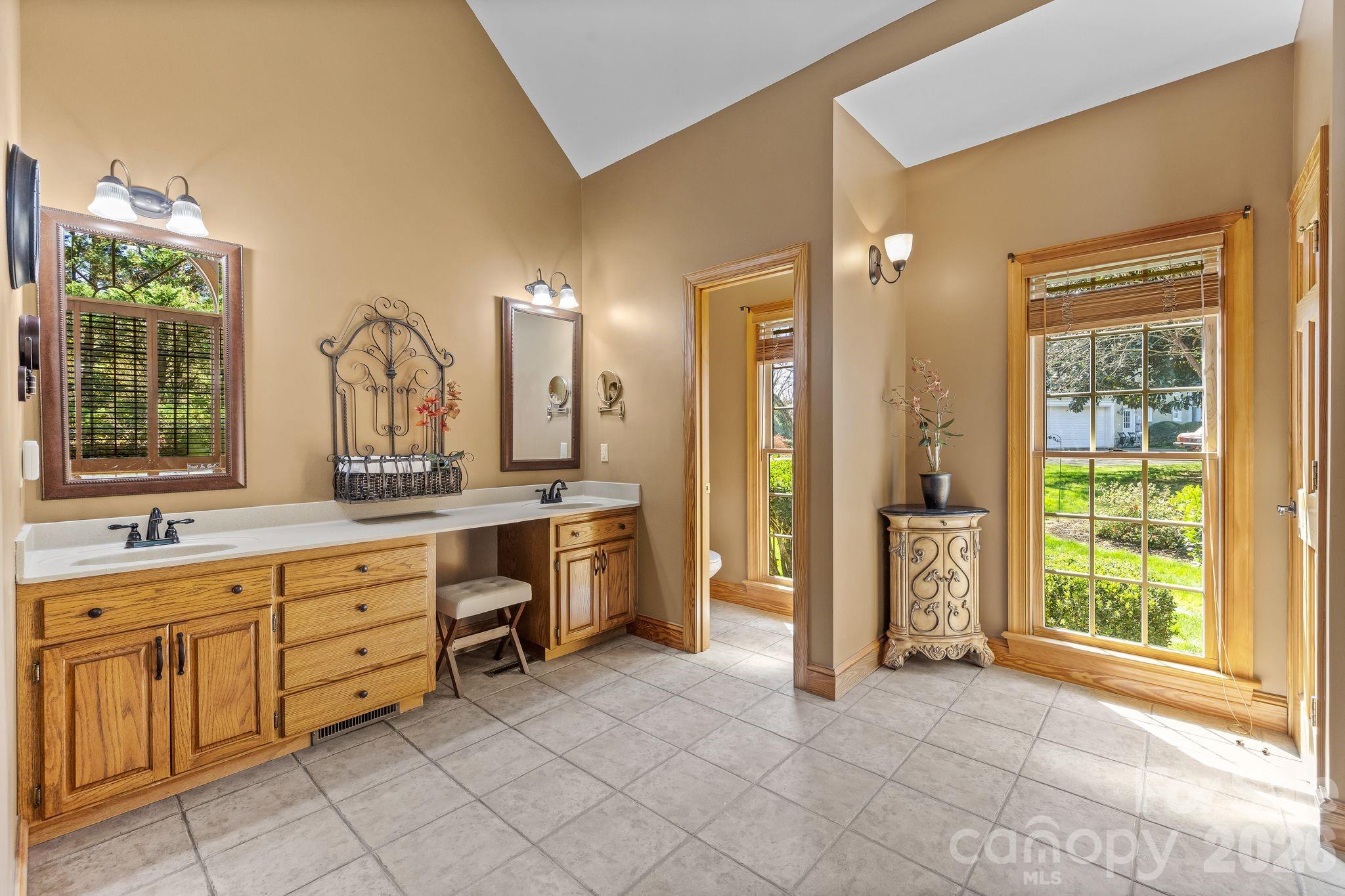 3530 Cardiff Lane Matthews, NC 28104 - Photo 23 of 39 a large bathroom with a double vanity sink a large mirror and a bathtub