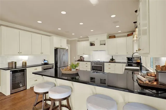 a kitchen with granite countertop white cabinets and stainless steel appliances