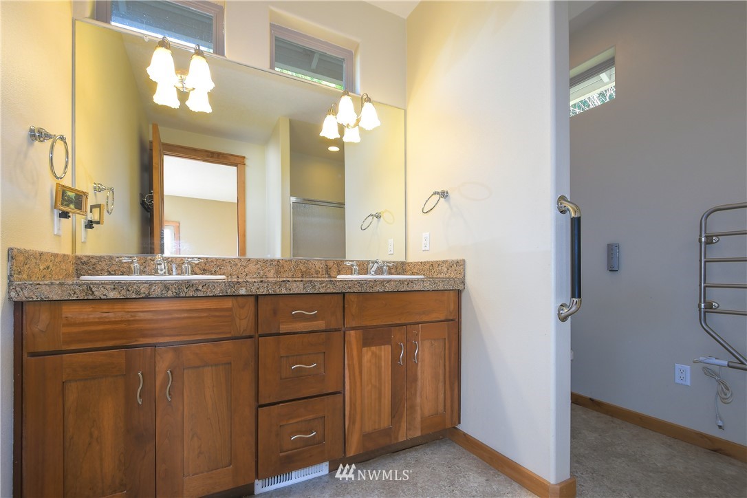 625 McAdams Road East Longview, WA 98632 - Photo 22 of 40 a bathroom with a granite countertop sink a large mirror and a shower
