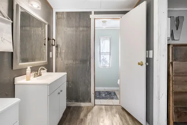 a bathroom with a sink a toilet a mirror and shower