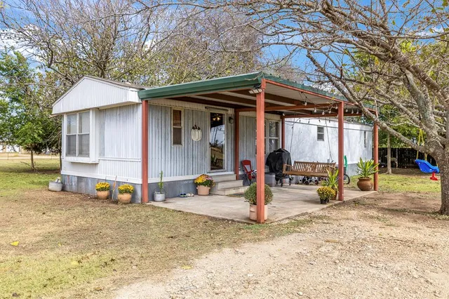 a view of a house with backyard and sitting area