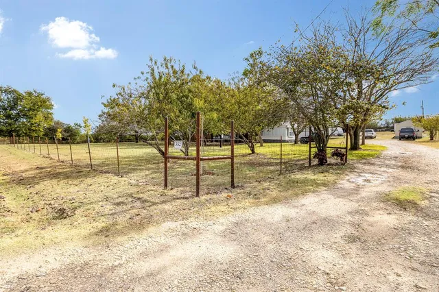 a view of yard with tree and wooden fence