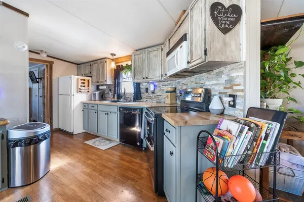 a kitchen with stainless steel appliances granite countertop a sink a stove and refrigerator