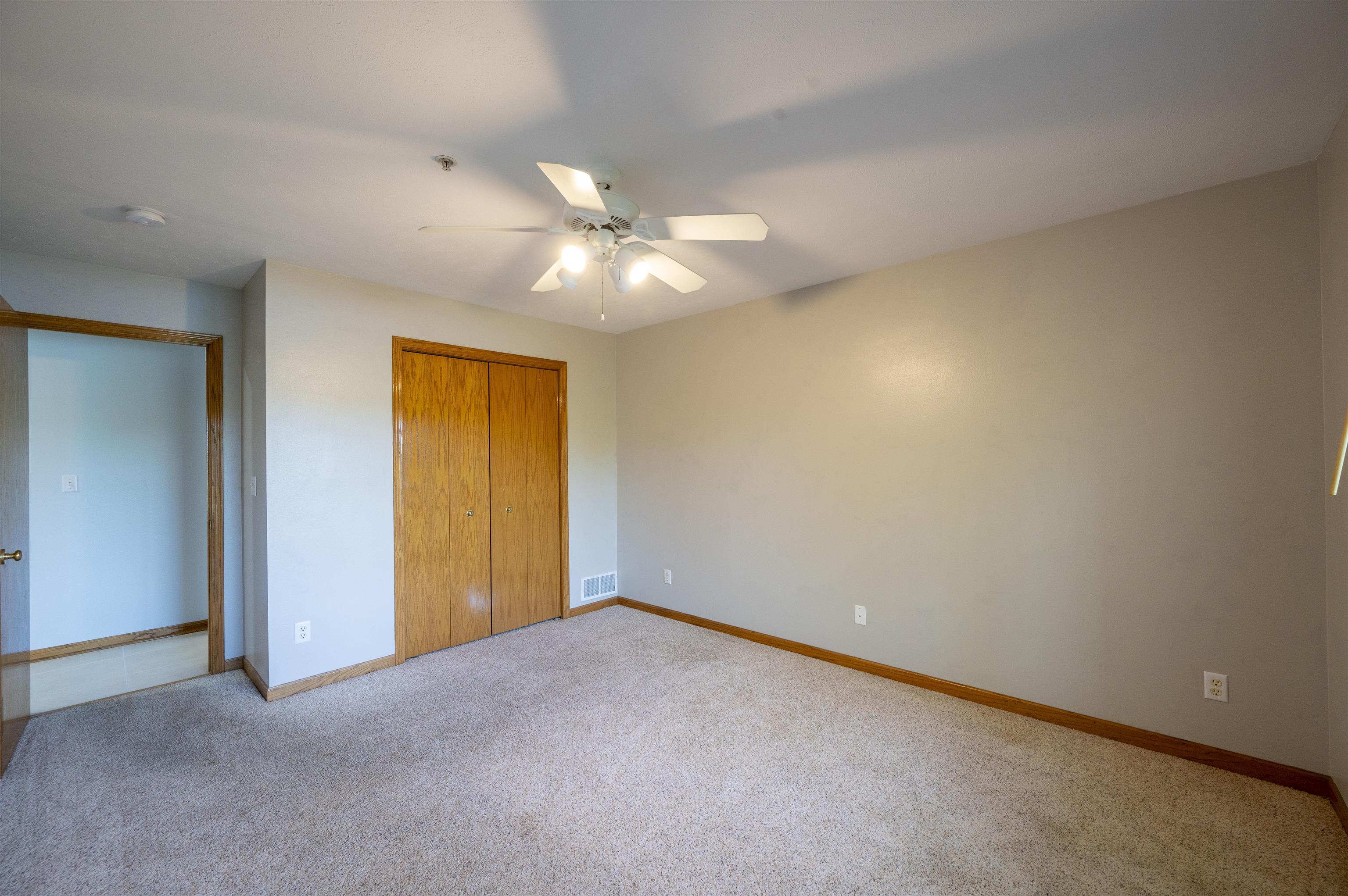 7280 North Alpine Road Loves Park, IL 61111 - Photo 15 of 17 an empty room with a chandelier fan and a ceiling fan