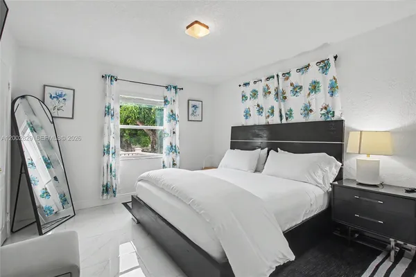 a bedroom with a bed and painting on the wall