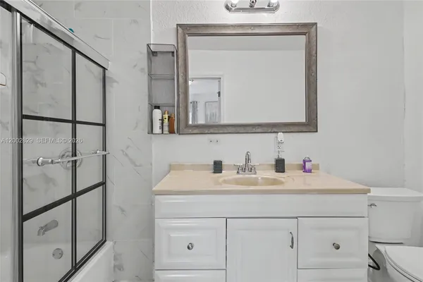a bathroom with a sink a toilet and shower