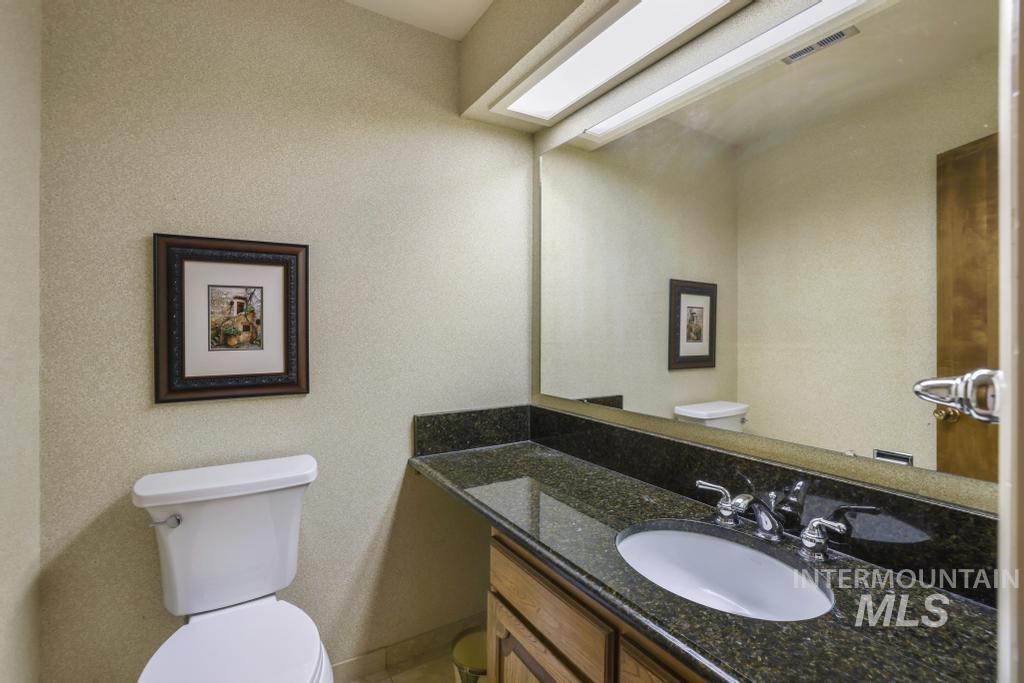 2018 Rancho Vista Drive Twin Falls, ID 83301 - Photo 34 of 50 Bathroom featuring a vanity with an undermount sink, granite countertop, and wood-finish cabinetry