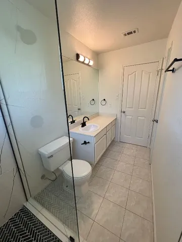 a bathroom with a sink a toilet a mirror and shower