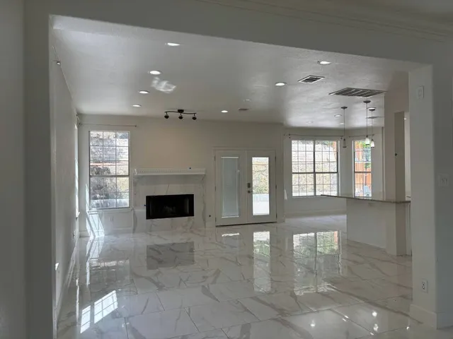 a view of a big room with windows and fireplace