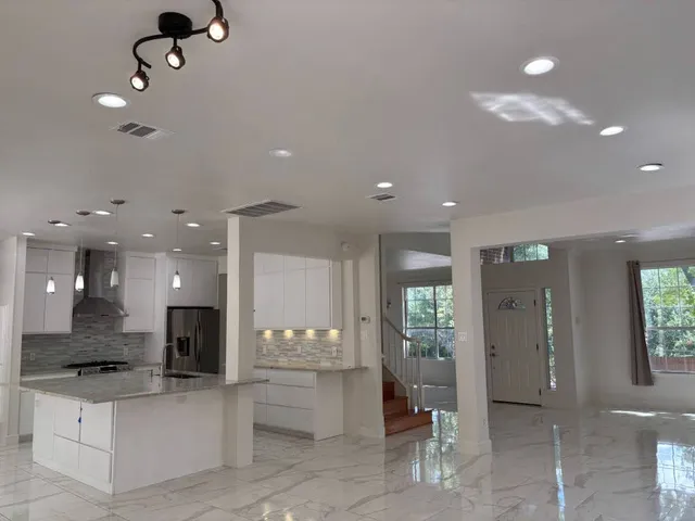 a view of kitchen with stainless steel appliances kitchen island a sink and a refrigerator