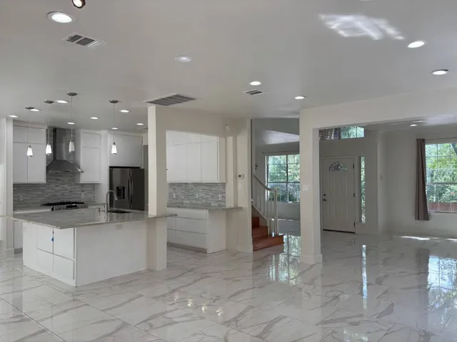 a large kitchen with a large counter top and stainless steel appliances