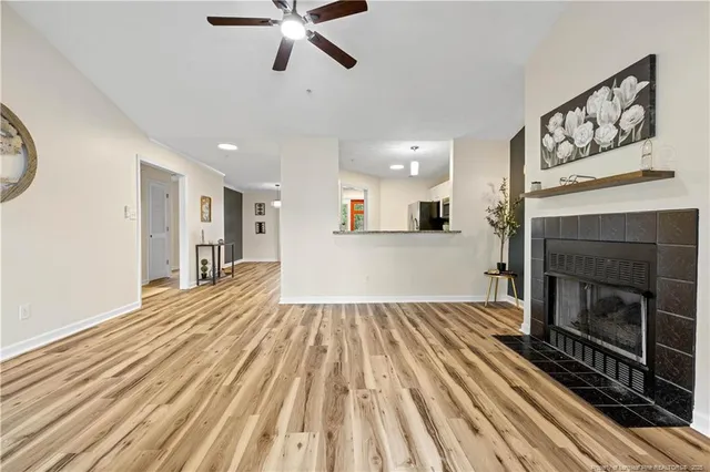 a view of a livingroom with wooden floor and a fireplace