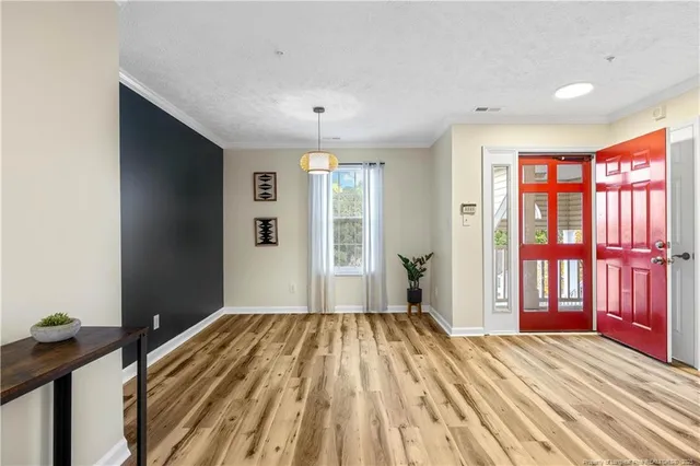 a view of a bedroom with a bed and wooden floor