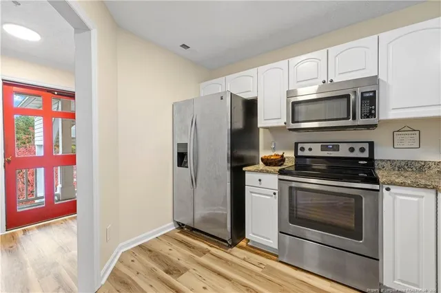 a kitchen with stainless steel appliances granite countertop a stove microwave and refrigerator