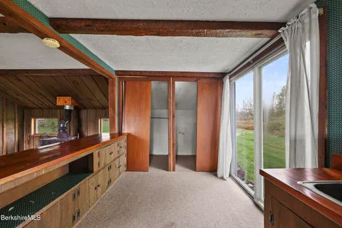 a view of a hallway with wooden floor and a ceiling fan