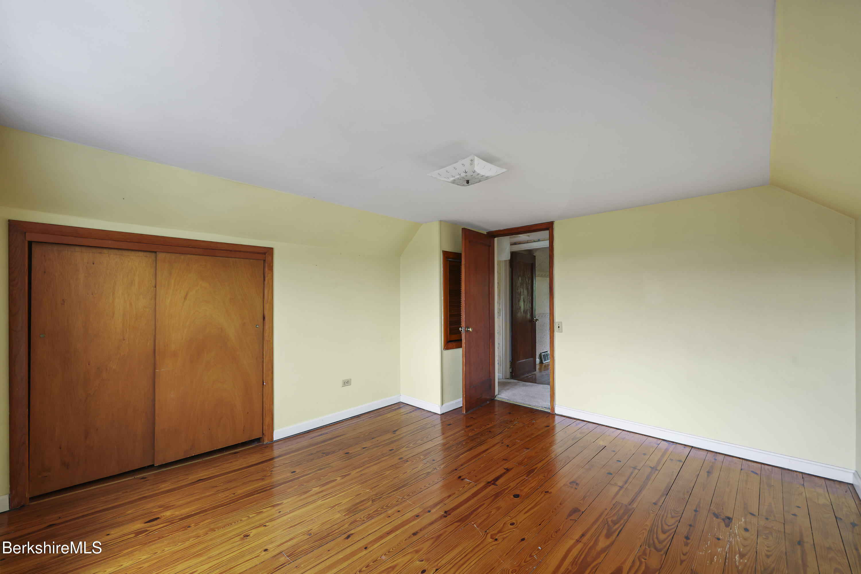 399 State Road Richmond, MA 01201 - Photo 32 of 43 an empty room with wooden floor and closet area