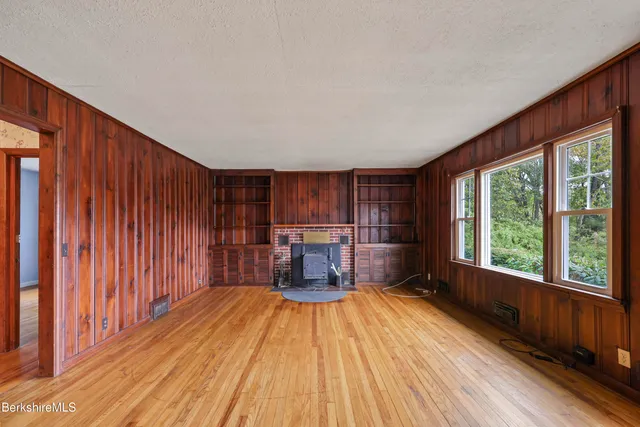 a view of a livingroom with wooden floor and furniture