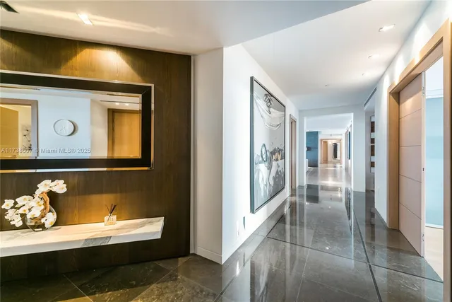 a view of a hallway to a livingroom with furniture