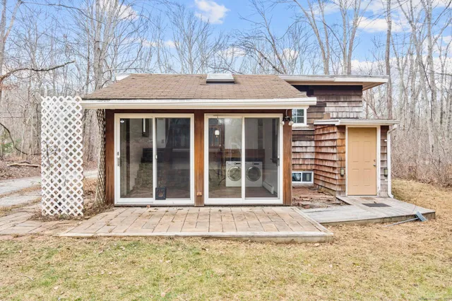 a view of a house with a large window and wooden fence