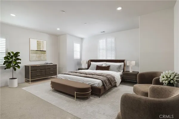 a spacious bedroom with a bed a couch and a potted plant