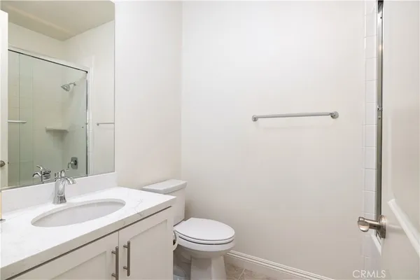 a bathroom with a granite countertop sink toilet and a mirror