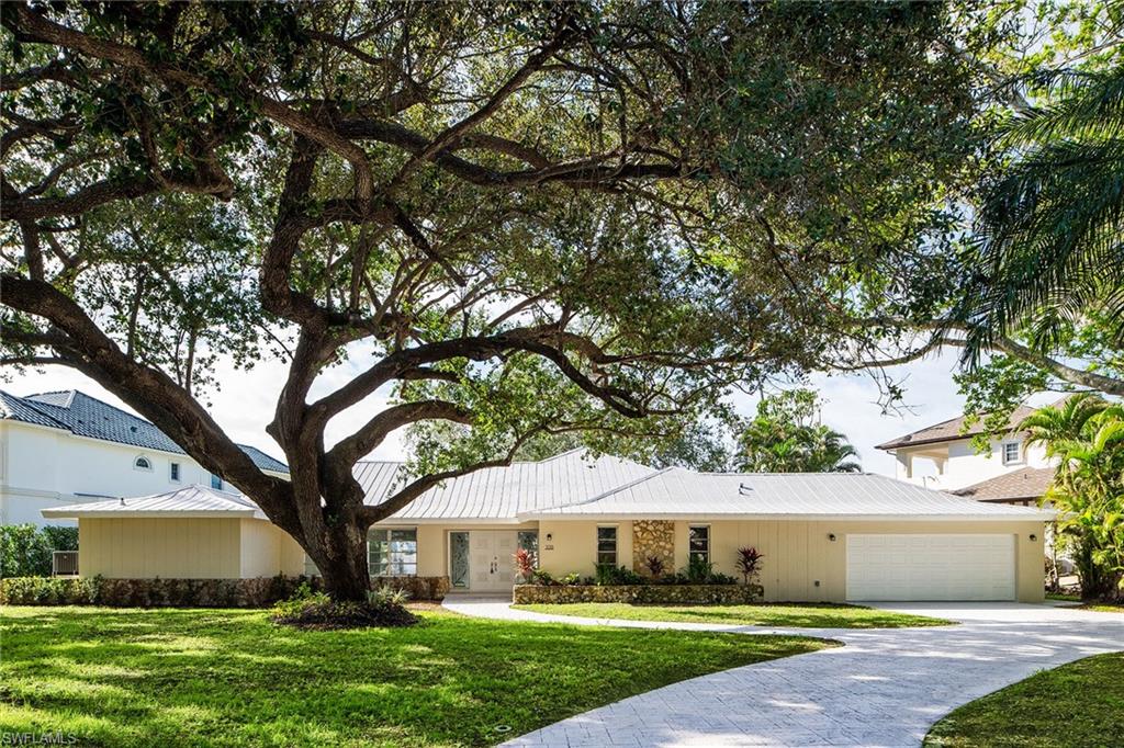 320 Bow Line Drive Naples, FL 34103 - Photo 1 of 20 a front view of a house with a garden and tree