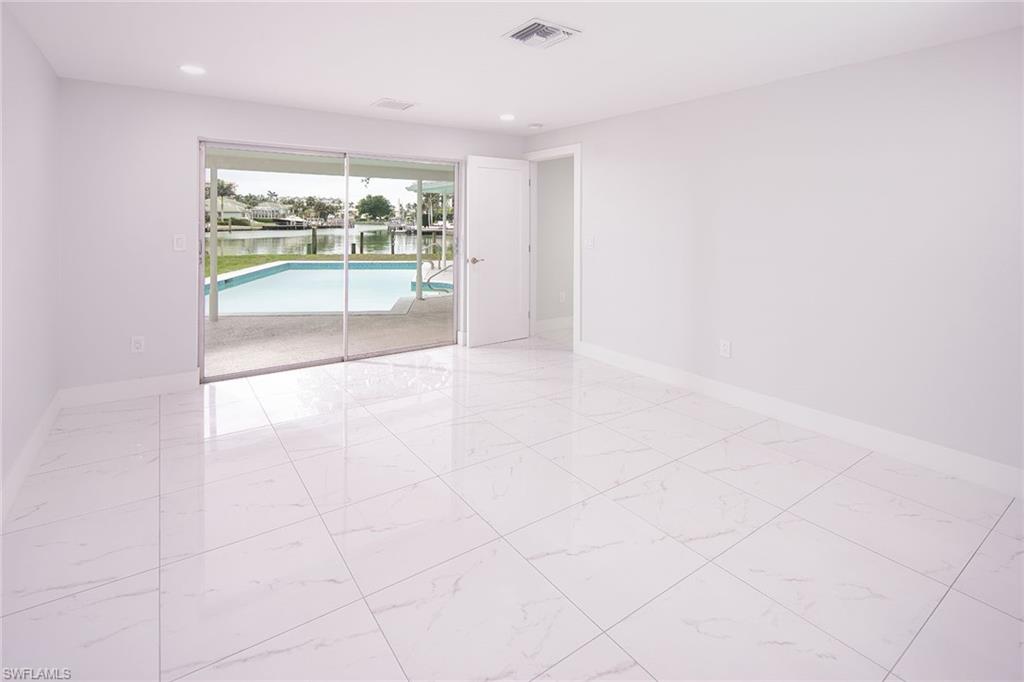 320 Bow Line Drive Naples, FL 34103 - Photo 15 of 20 an empty room with floor to ceiling windows and outdoor view