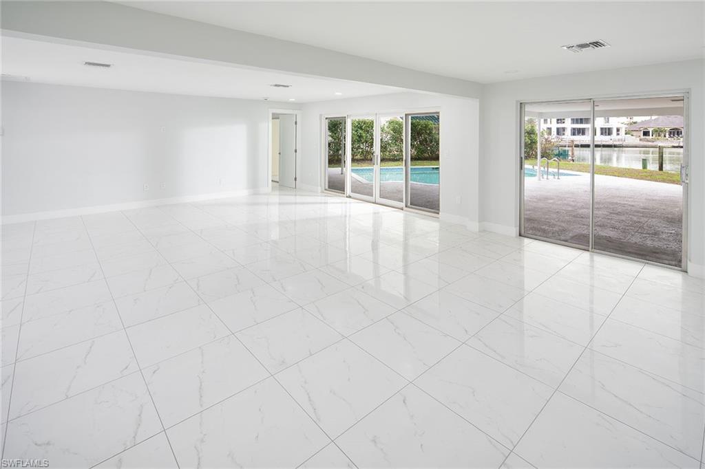 320 Bow Line Drive Naples, FL 34103 - Photo 10 of 20 an empty room with floor to ceiling windows and chandelier