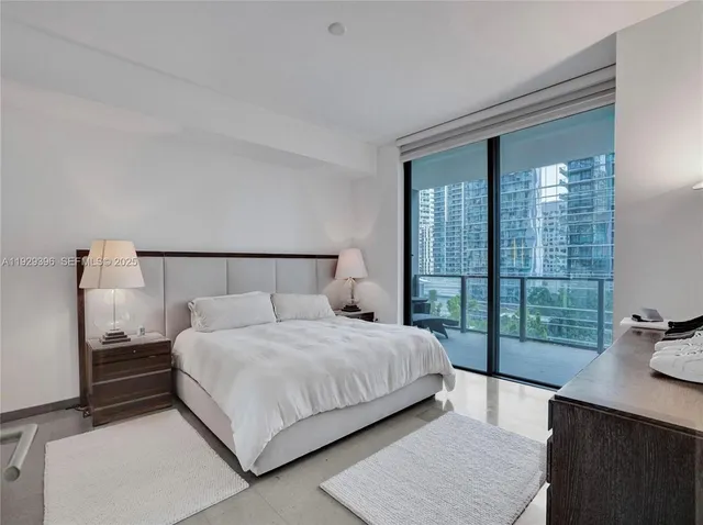 a bedroom with a bed and a large window