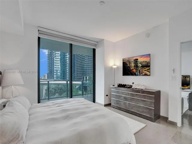 a bedroom with a bed and a flat screen tv