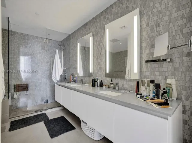 a bathroom with a sink a mirror and a shower