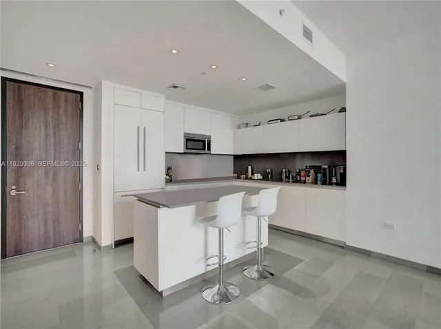 a kitchen with stainless steel appliances a refrigerator sink and white cabinets