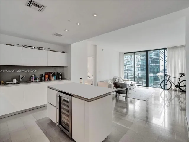 a large kitchen with kitchen island a large counter top space a sink a stove and a refrigerator