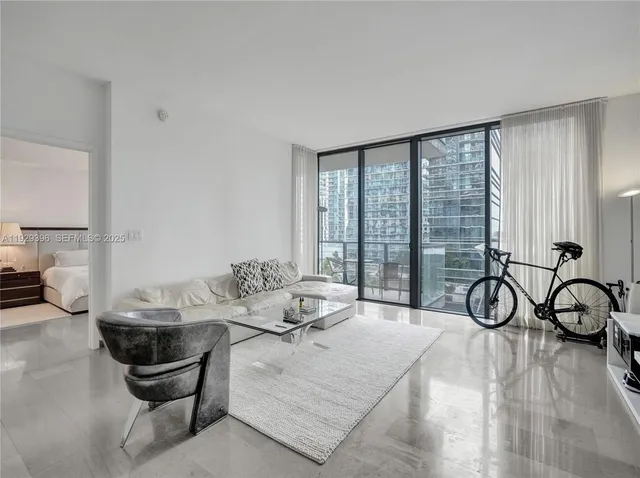 a living room with furniture a table and a large window