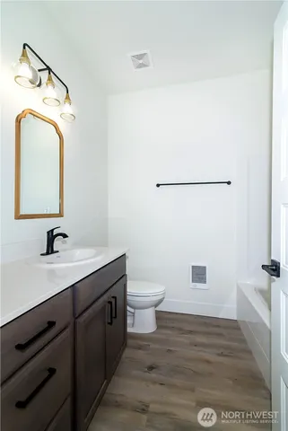 a bathroom with a toilet a sink and mirror
