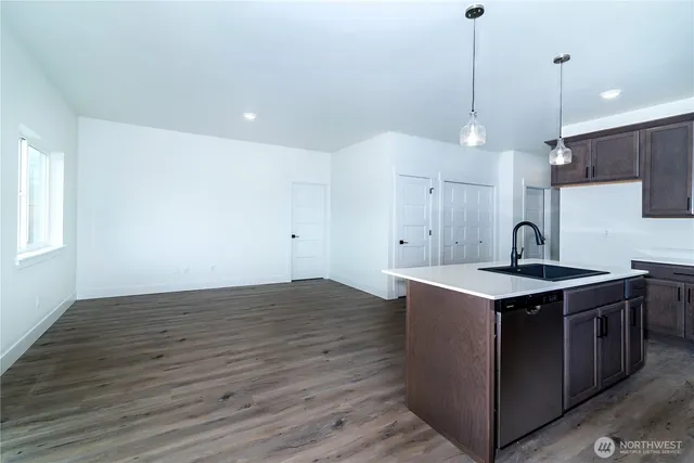 a kitchen with a sink cabinets and wooden floor