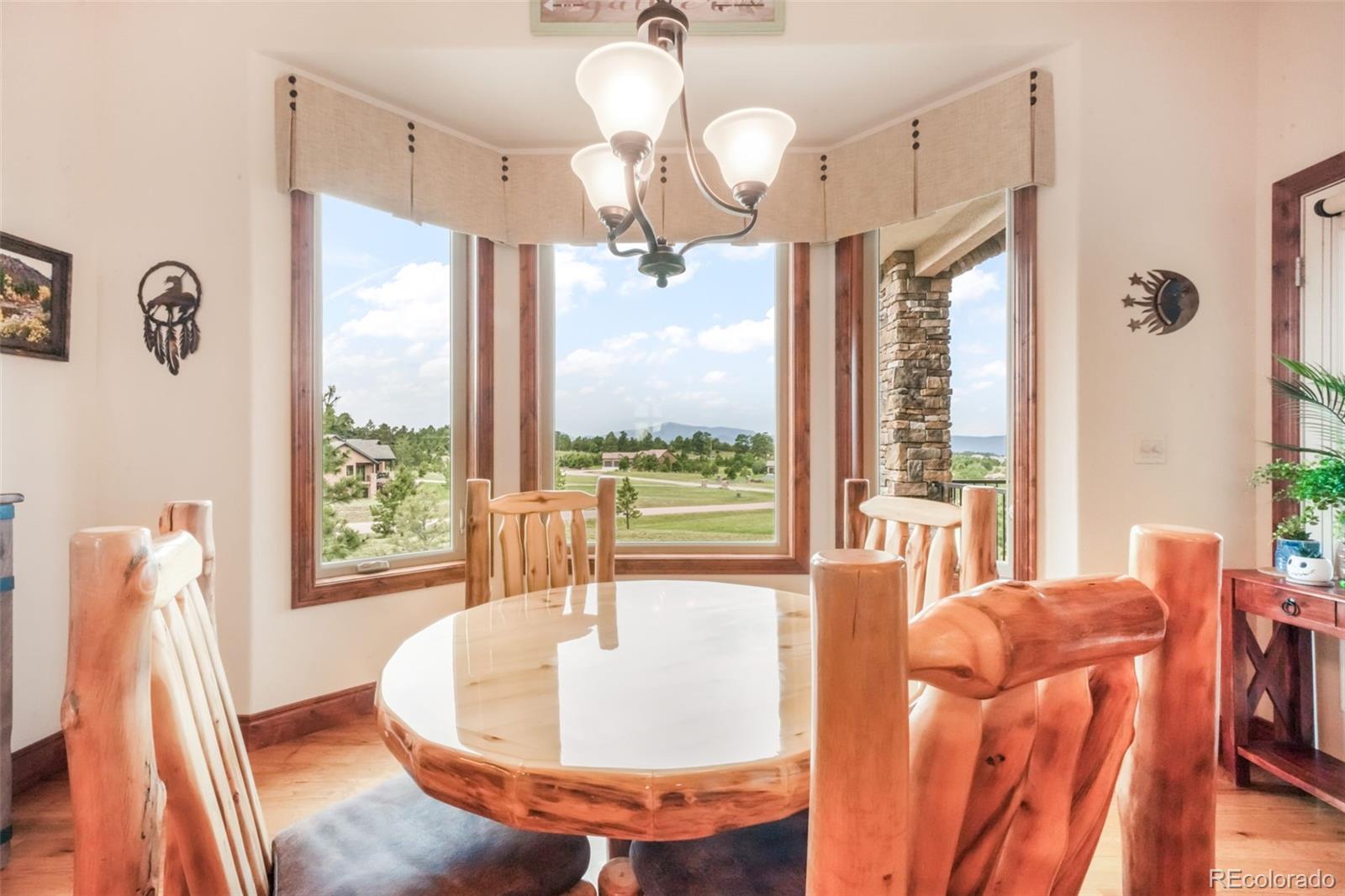 4330 Settlers Ranch Road Colorado Springs, CO 80908 - Photo 16 of 50 a view of a dining room with furniture a chandelier and large windows