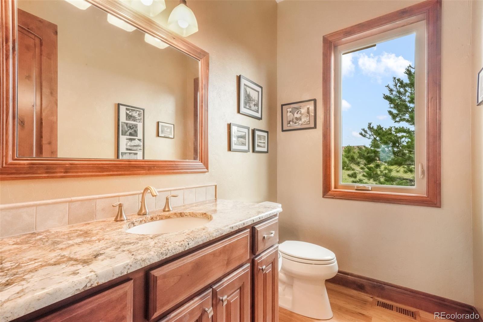 4330 Settlers Ranch Road Colorado Springs, CO 80908 - Photo 17 of 50 a bathroom with a granite countertop sink mirror vanity and toilet